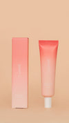 Coral-colored tube and packaging on a beige background